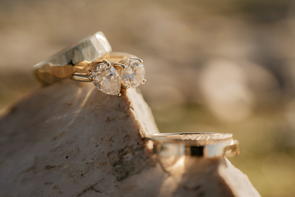 Gold rings with diamonds on a rock