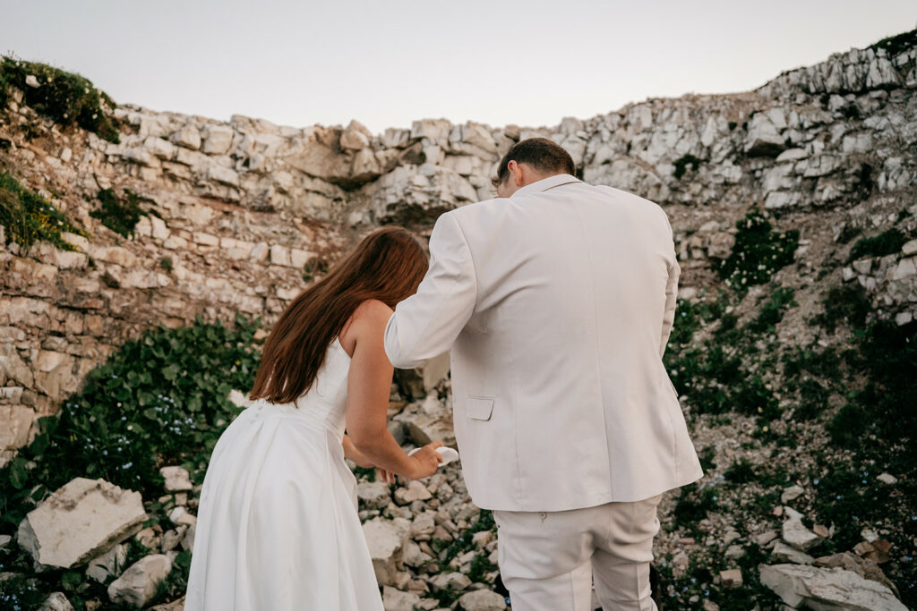 Couple exploring rocky landscape in formal attire