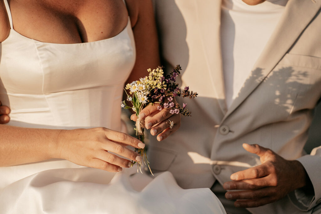 Couple holding small wildflower bouquet.