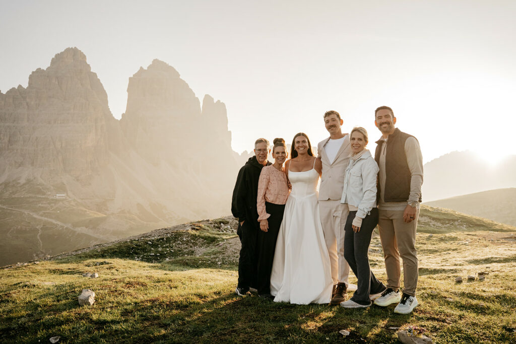 Group posing before mountains at sunset.