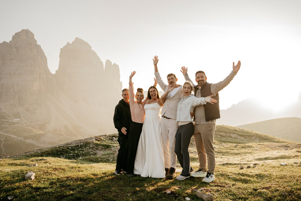 Group celebrates with mountains in the background at sunset.
