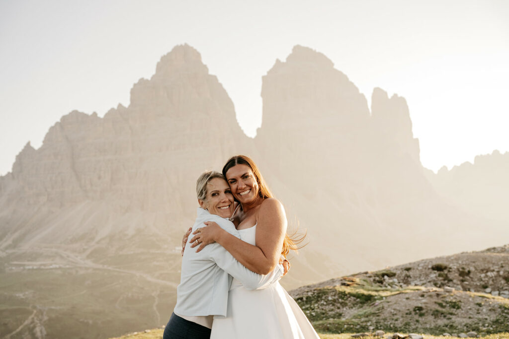 Two women hugging in mountain landscape