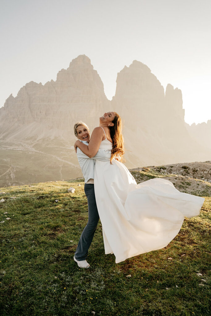 Couple laughing outdoors in scenic mountain landscape.
