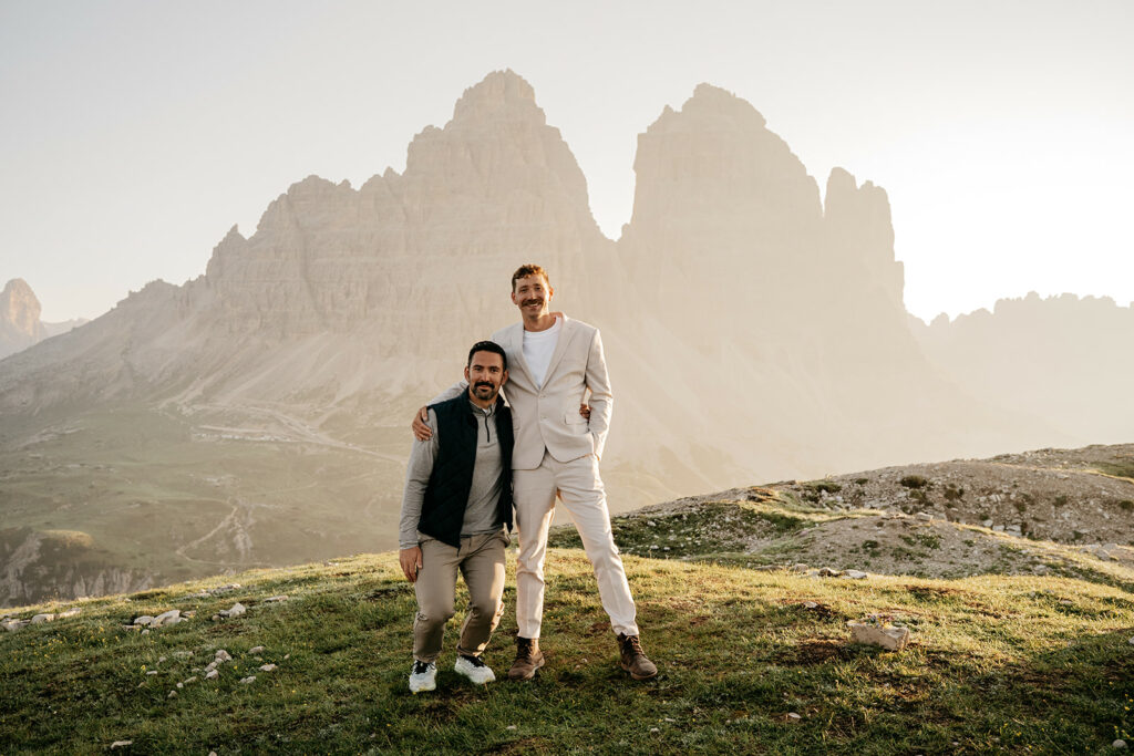 Two people posing in front of mountains at sunset.