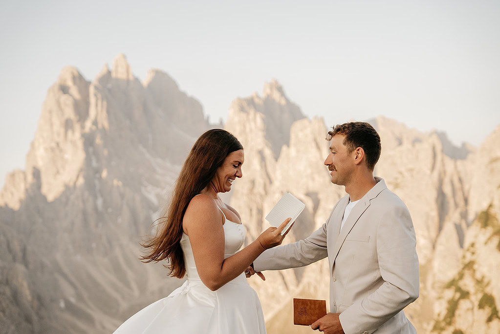 Couple exchanging vows in mountain setting.