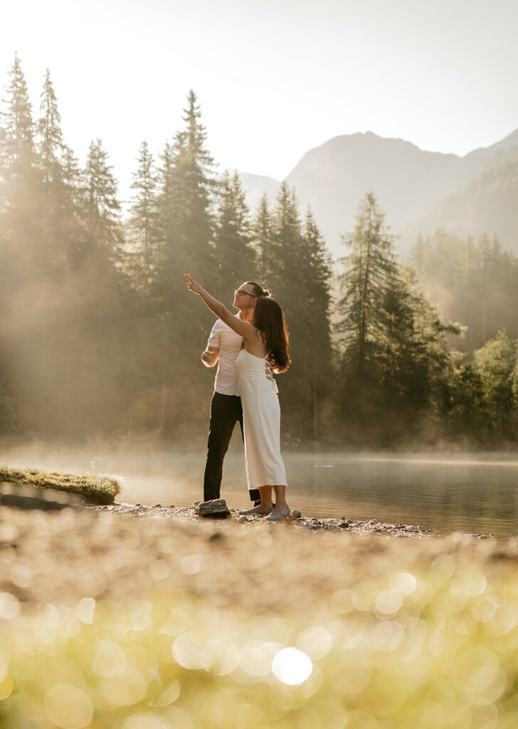 Couple enjoying nature by serene lake and mountains.