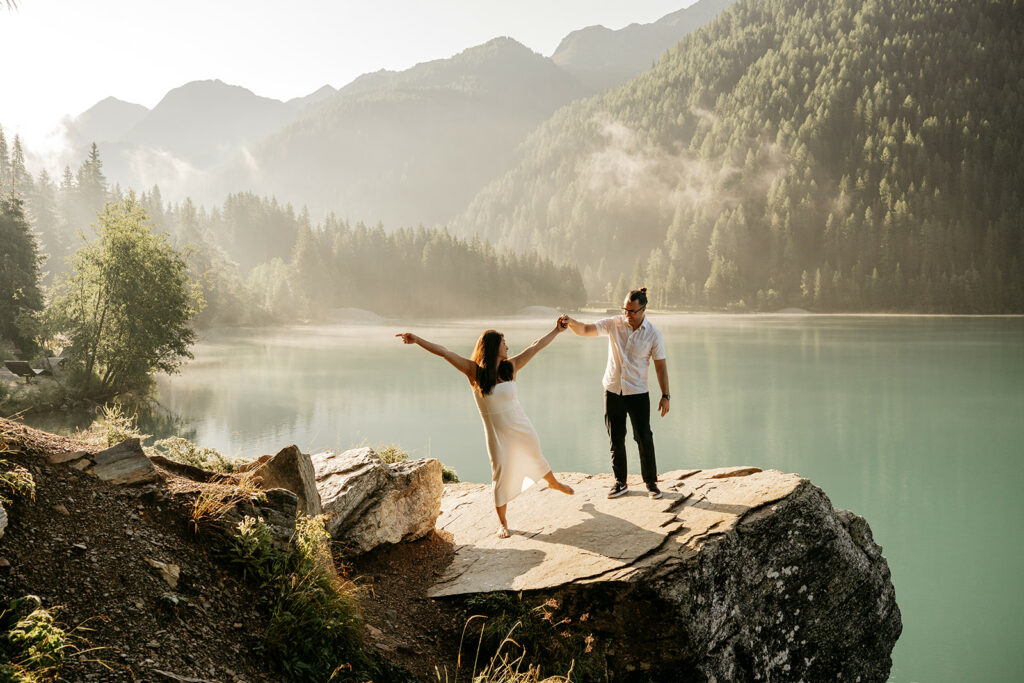 Couple dancing by a serene mountain lake.