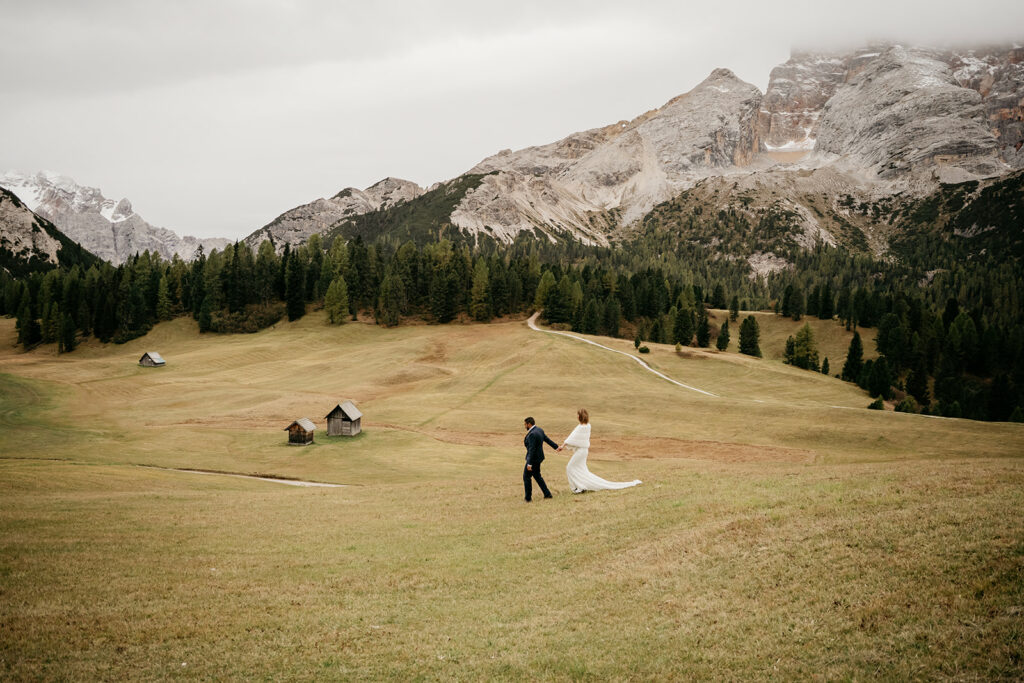Couple walking in alpine meadow landscape.