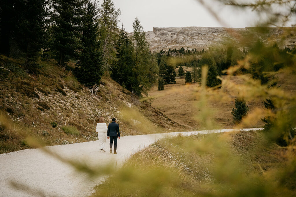 Couple walking on forest path in fall landscape.