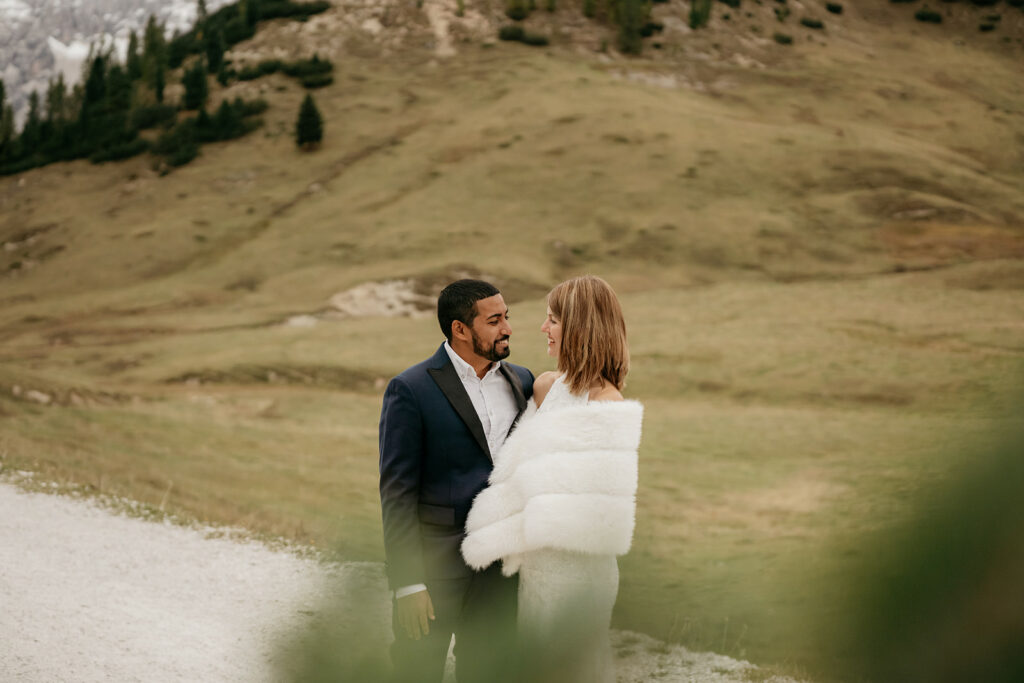 Couple embraces in picturesque mountain landscape.