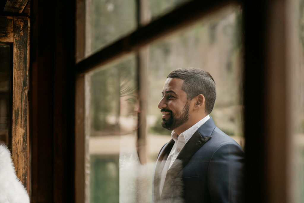 Man smiling through window reflection