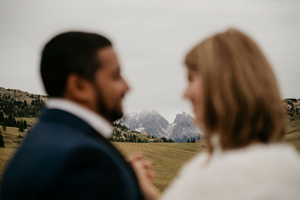 Couple blurred, mountain landscape in background.