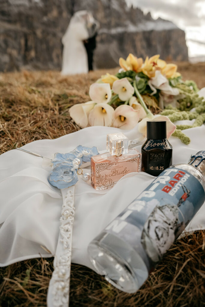 Wedding items on grass with couple in background.