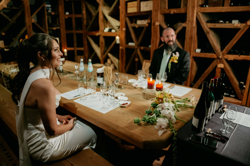 Couple dining in cozy candlelit wine cellar.
