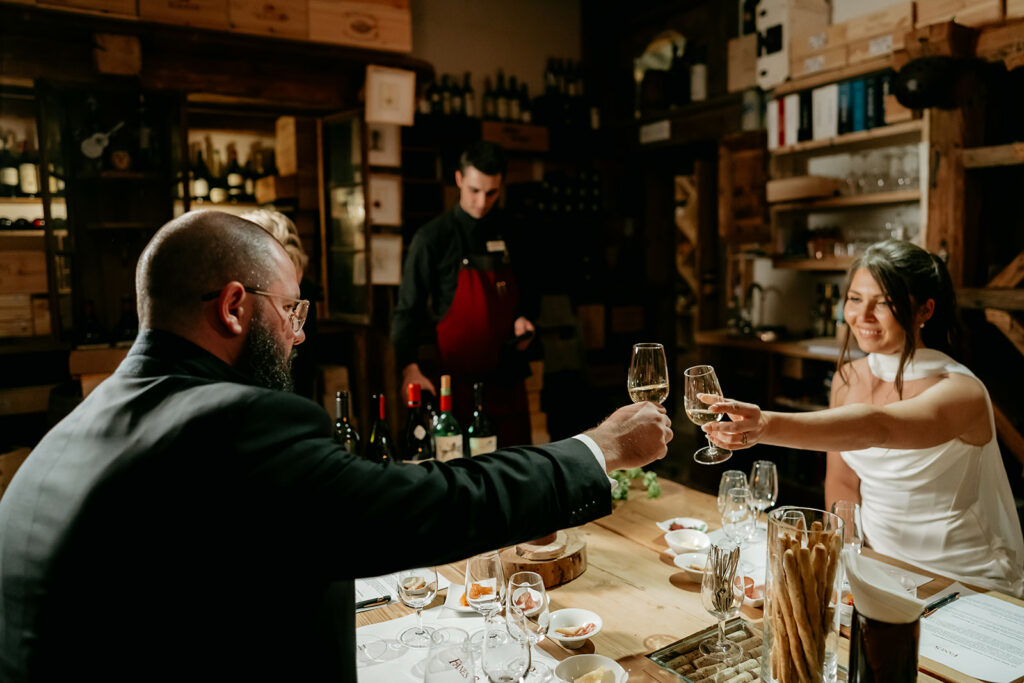 Couple toasting in a wine cellar dinner setting.