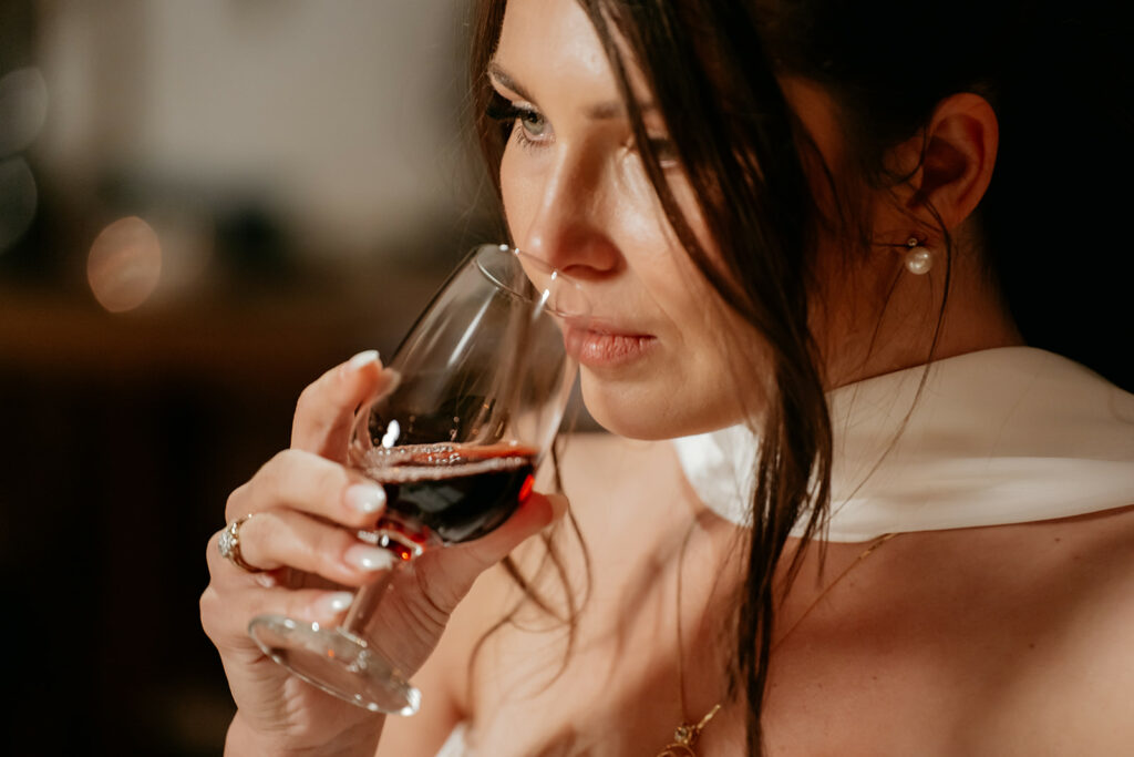 Woman smelling red wine in glass