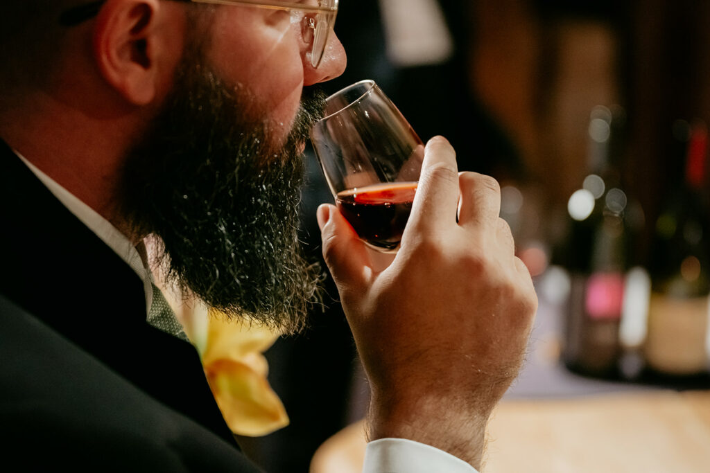 Man tasting red wine at a event.