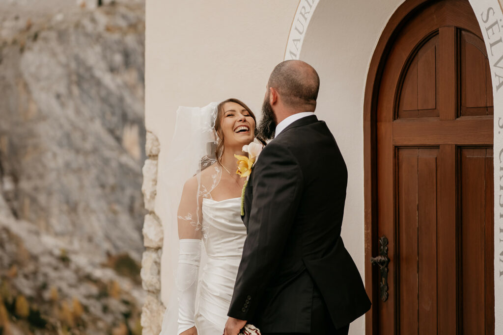 Happy couple laughing during outdoor wedding ceremony.
