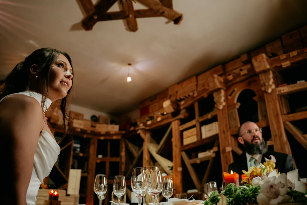Woman in white dress at elegant dinner table.