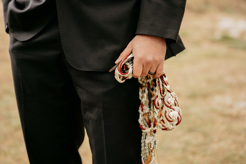 Person holding intertwined cords in formal attire