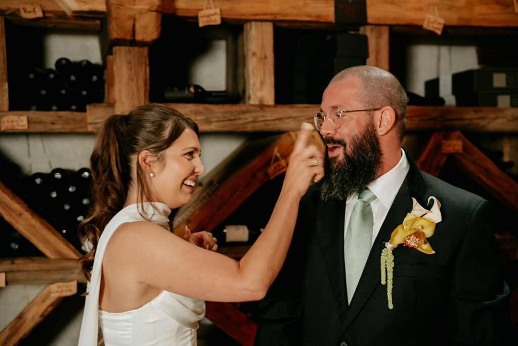 Woman playfully touches man's nose, both smiling.