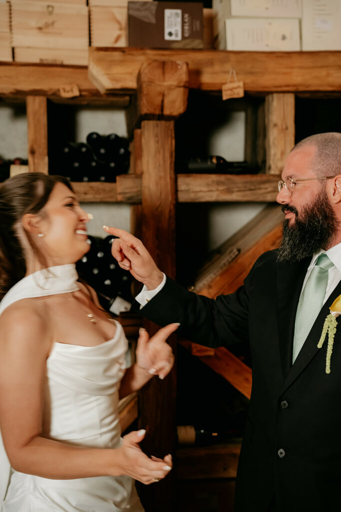 Couple celebrating during wedding in wine cellar.