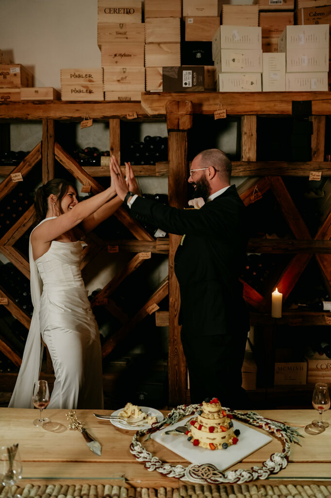 Bride and groom celebrating in wine cellar.
