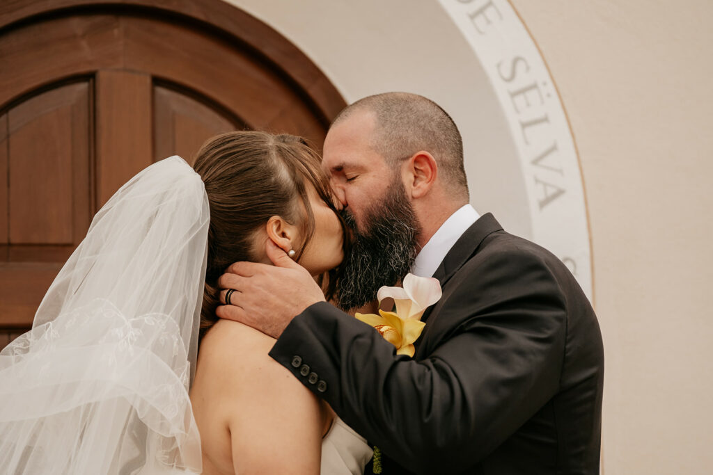 Bride and groom kissing at wedding ceremony