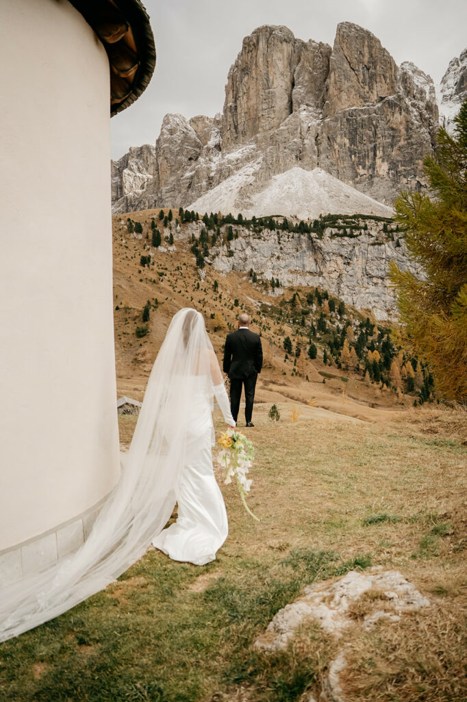 Bride approaches groom in mountainous landscape