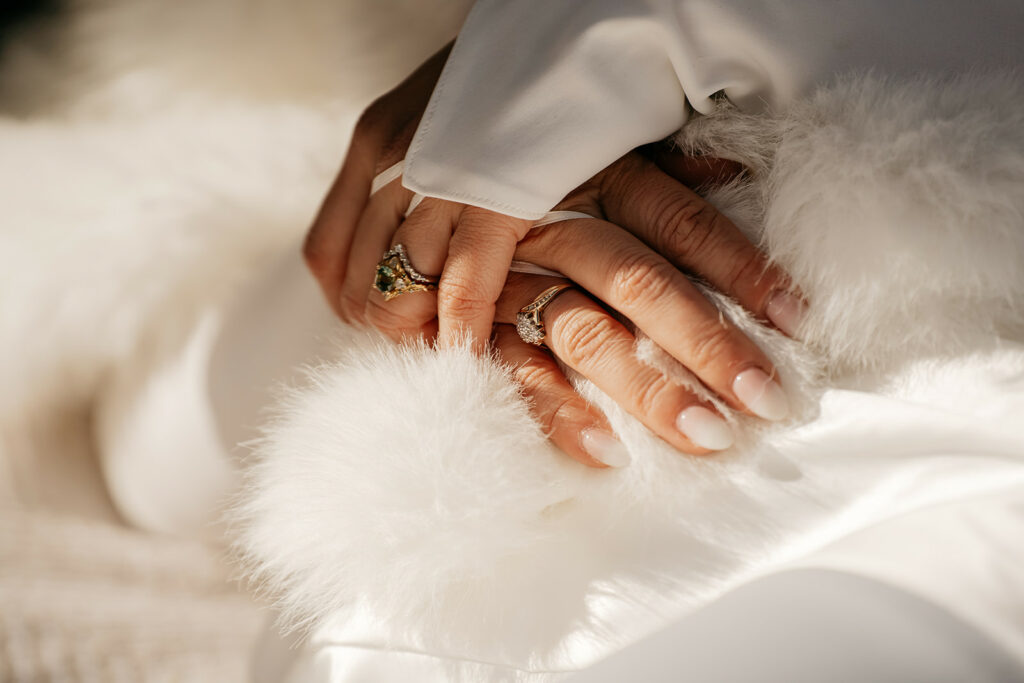 Hands with elegant rings and white fur.