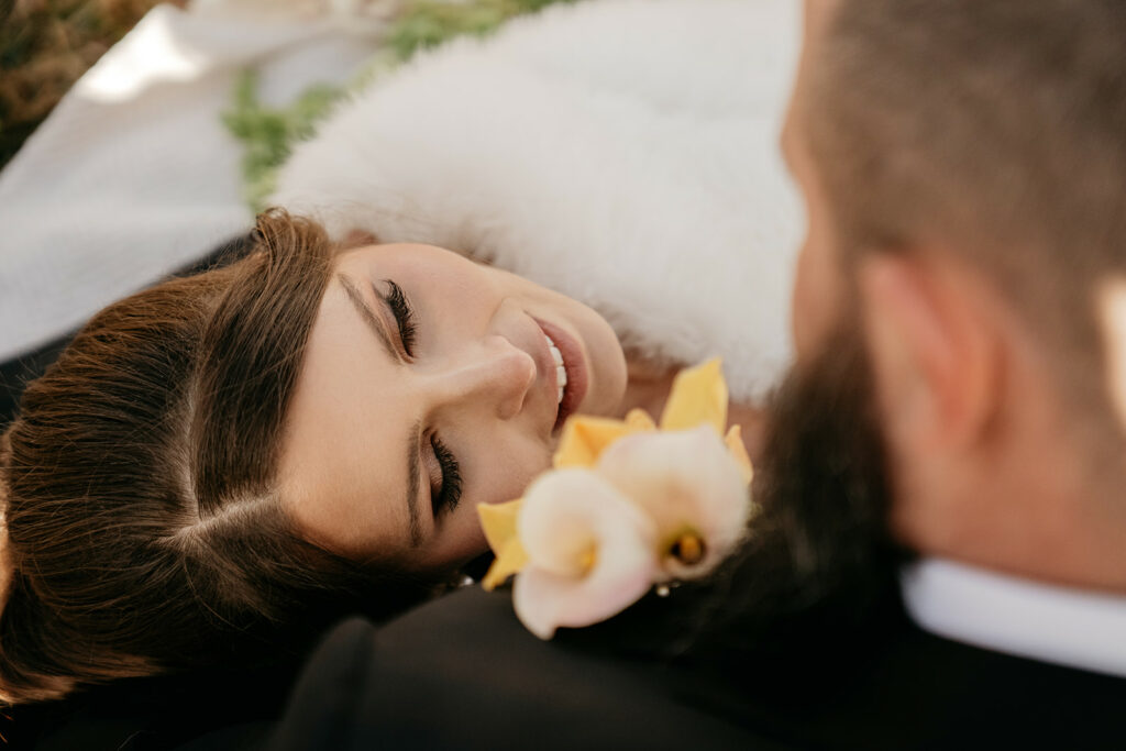 Bride smiling at groom with flowers