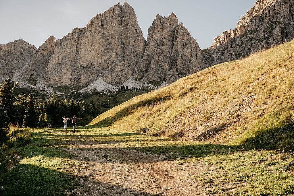 Hikers explore scenic mountain landscape under rocky peaks.