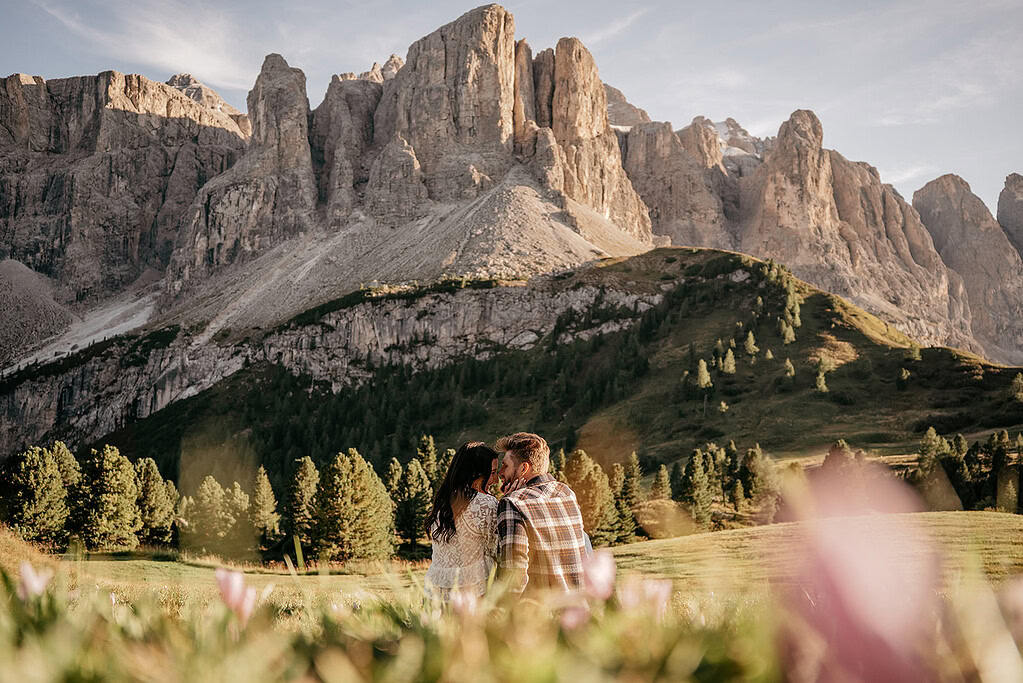 Couple sitting in front of a mountain landscape.