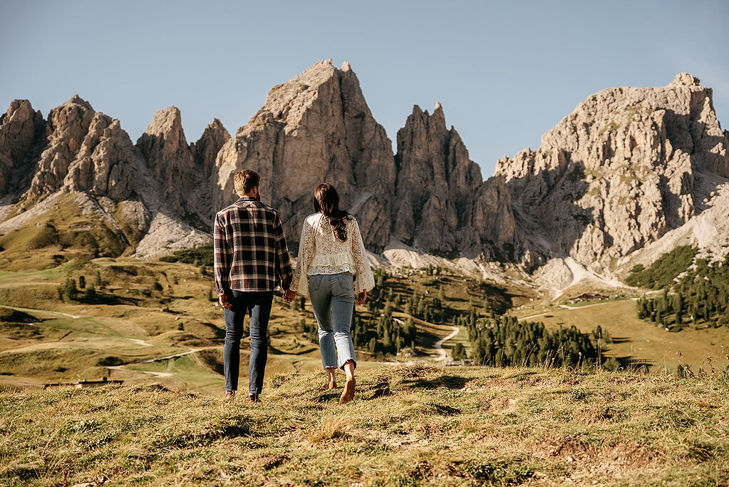 Couple walking towards mountain in scenic landscape