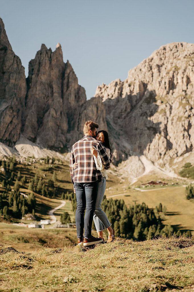 Couple embracing in mountain landscape.