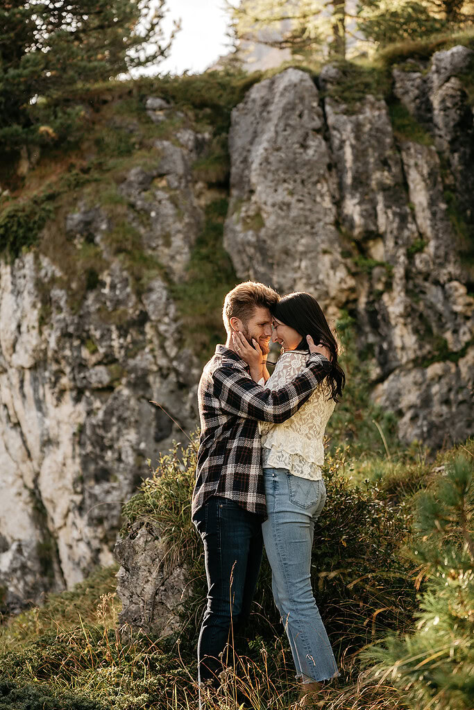 Couple embracing in scenic mountain landscape.