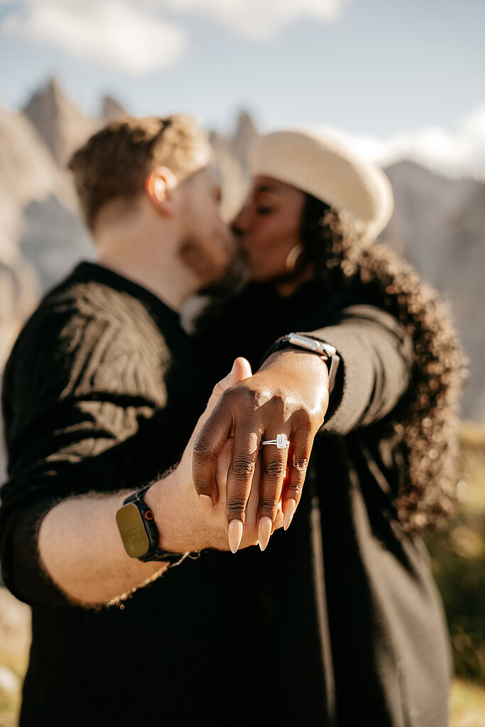 Couple holding hands, showing engagement ring.