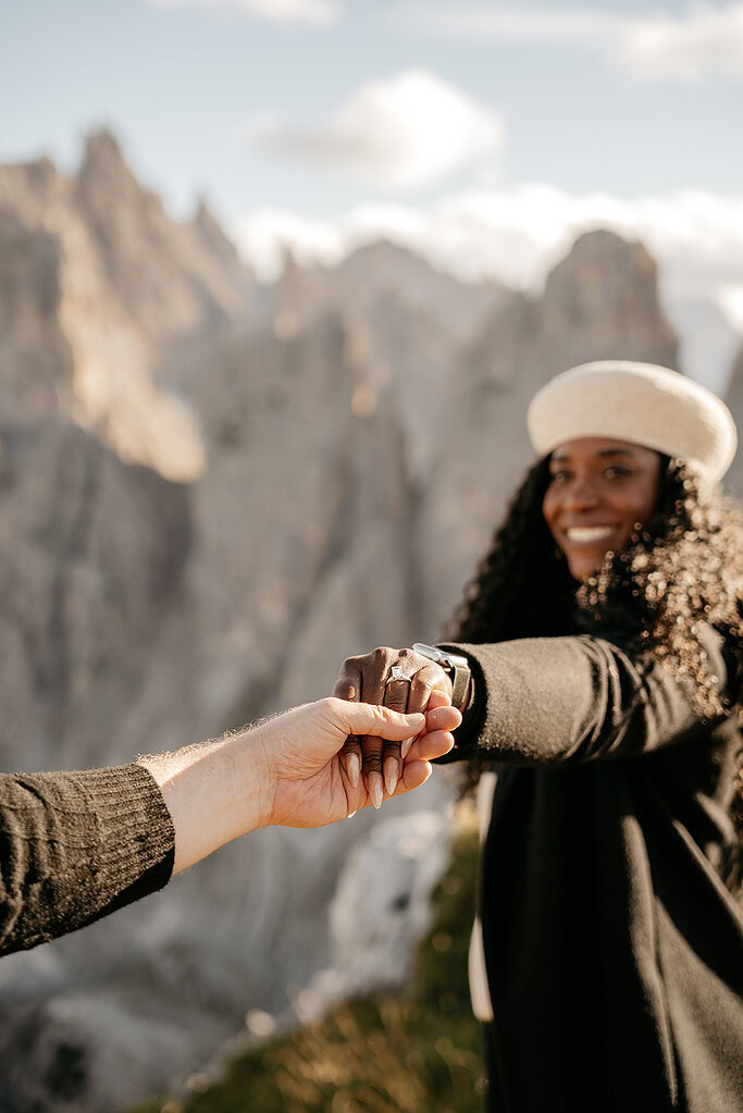 Smiling woman holding hand with mountain view