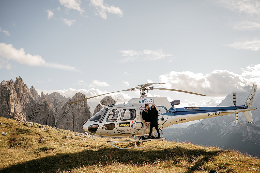 Helicopter landing on mountain with passengers.
