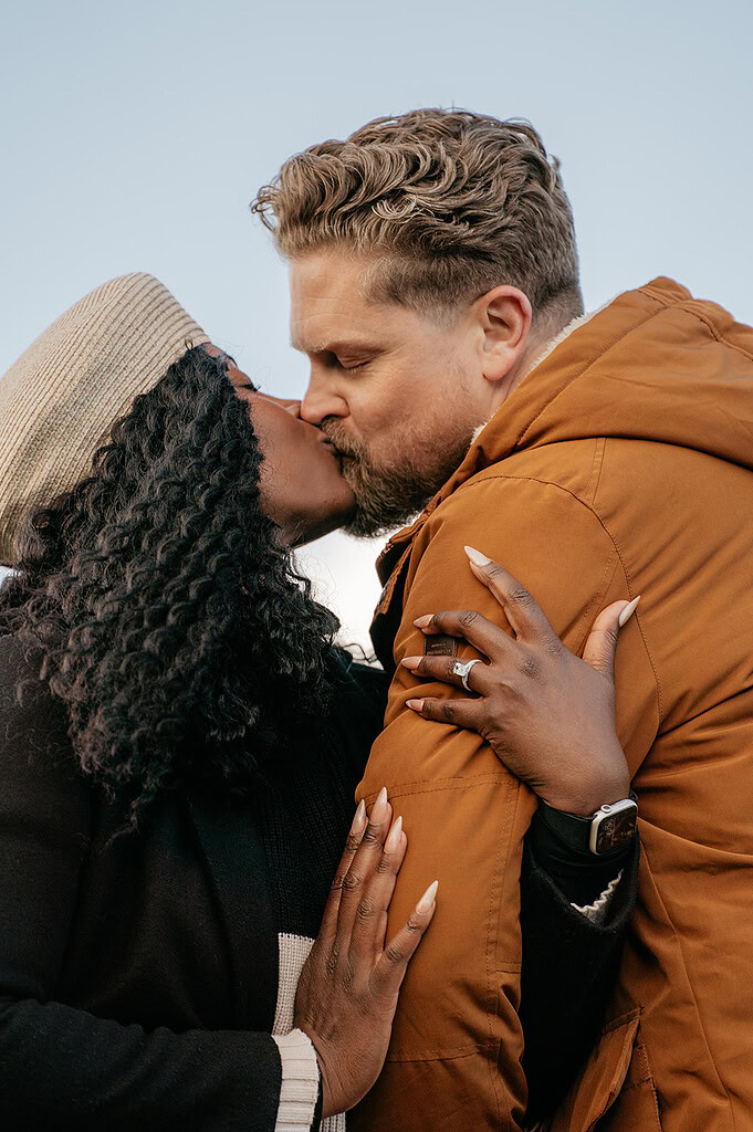 Couple sharing a romantic kiss outdoors.