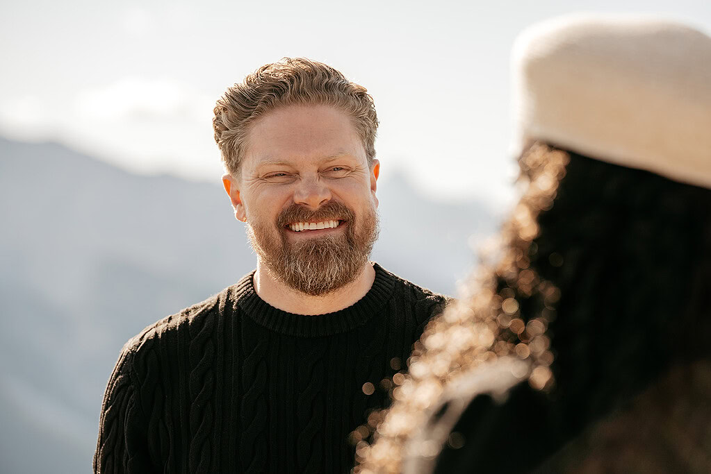Man smiling outdoors in sunny setting