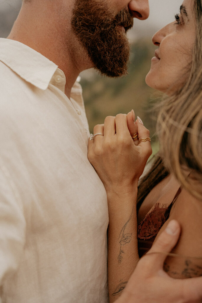 Couple embracing, close-up on hands and faces.