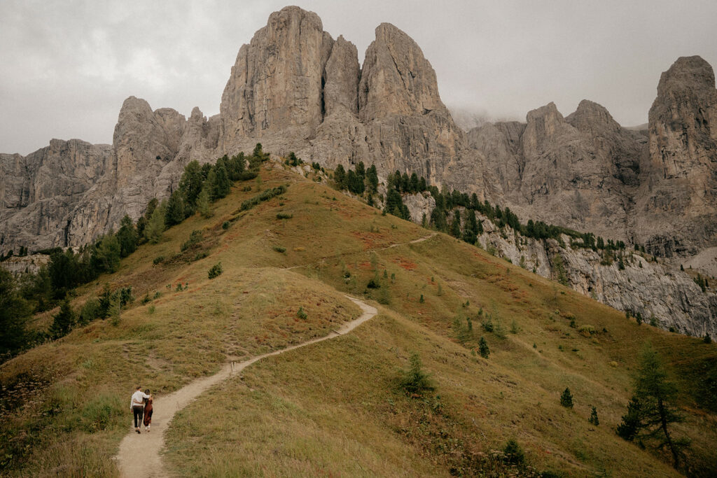 Hikers on mountain trail, rocky peaks background