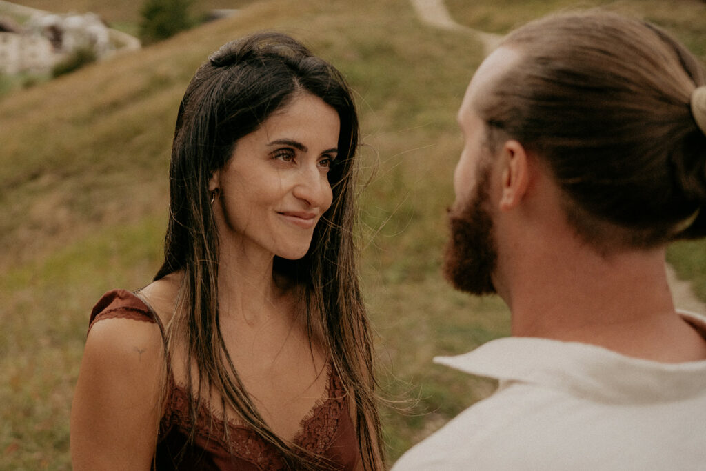 Couple smiling at each other outdoors in nature.