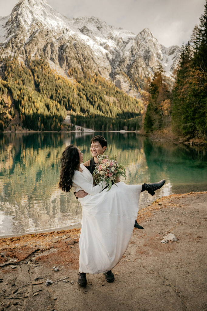Couple in wedding attire near mountain lake
