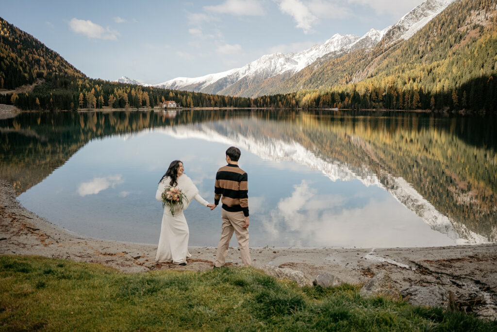 Couple holding hands by a picturesque lake