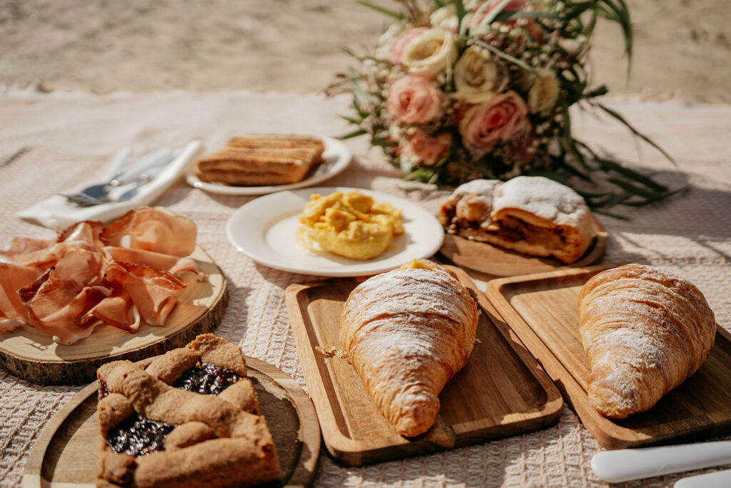 Beach picnic with pastries and flowers