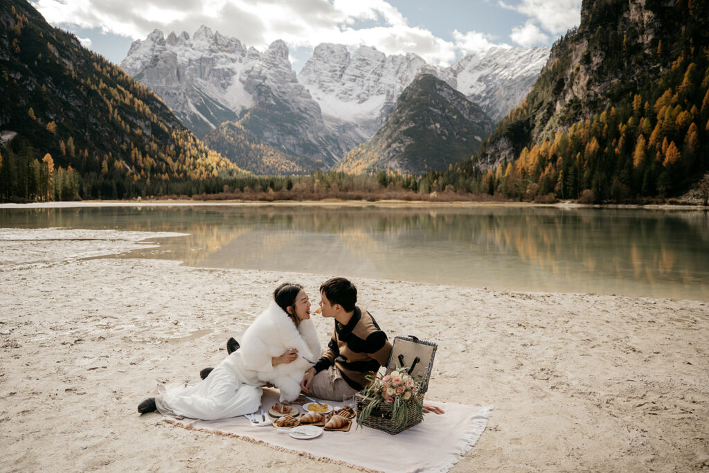 Couple having picnic by mountain lake.