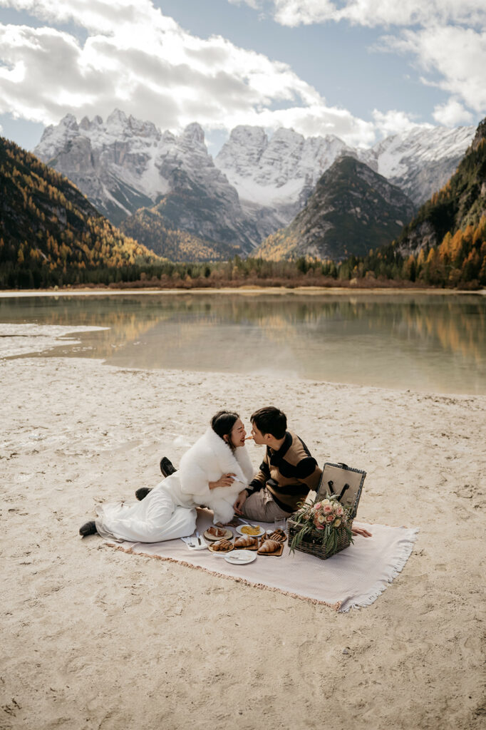 Couple having romantic picnic by mountain lake.