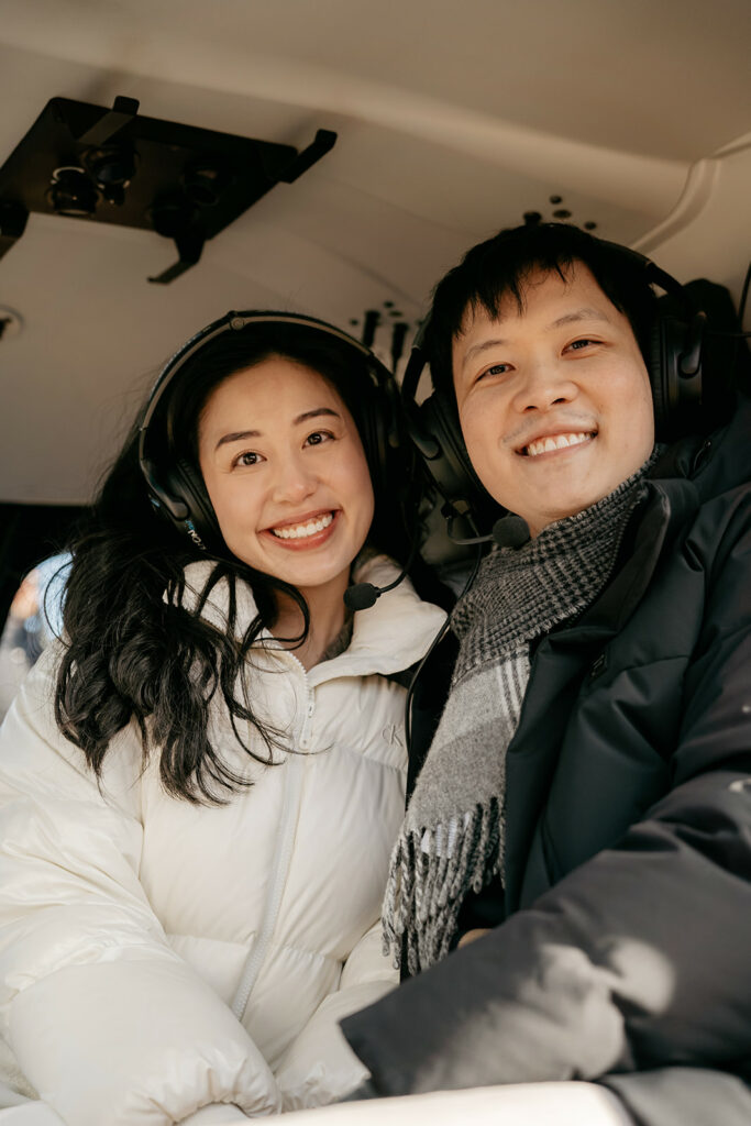 Smiling couple in helicopter wearing headsets.
